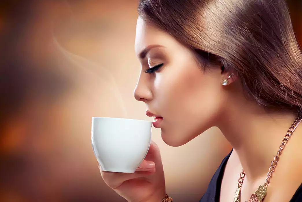 Vrouw drinkt een zicht baar geurig kopje koffie